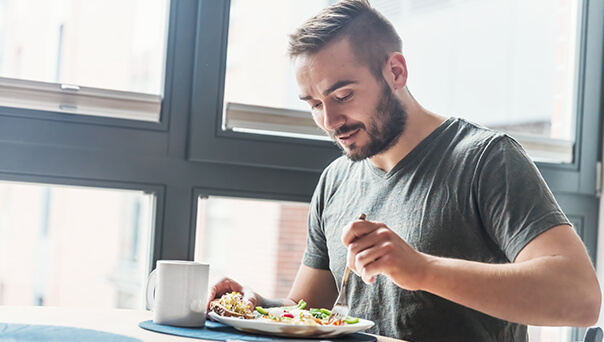 Man in grey shirt eating healthy food